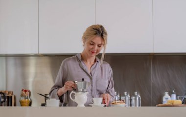 Sabahları mutfakta oturup kahve içen seksi bir kadın.