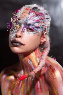 Vücut sanatı. Yüz rengi tasarımı. Renkli güzel kadın yüzü. Yaratıcı sanat makyajlı güzel bir manken. Yaratıcı vücut sanatı ve saç modeli. Boyalı kadın. Çekici kadın yüz sanatı