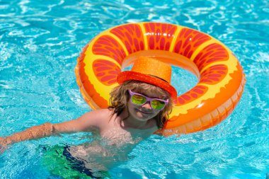 Çocuk yüzüyor ve havuzda oynuyor. Çocuk yüzme havuzunda oynuyor. Yaz tatili kavramı. Yaz çocuklarının portresi. Moda yaz çocukları şapkası.