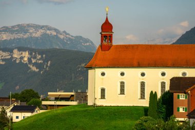 Alplerdeki kilise. İsviçre 'de Lucerne Gölü' nün yanındaki kilise. İsviçre köyündeki Alp dağlarındaki kilise. Alplerin kırsal kesimindeki dağların yakınındaki göl kenarındaki kırsal kilise. Dağ köyü