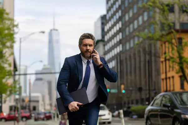 stock image Businessman with phone run in NY. Business talk. Businessman run down street talking on the phone. Man in suit late. Business call. Running business man. Fast business. Run and late businessman