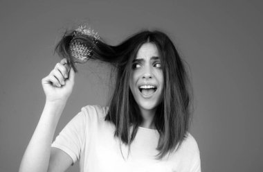 Yakın çekim saç dökülmesi, saç fırçasına düşen saçlar, taraklı bir kadının stres sorunu.