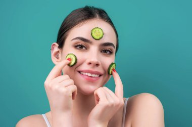 Salatalık maskesi. Kozmetik, kozmetik, dermatoloji. Salatalık maskeli kadın yüzü. Yüzünde salatalık dilimleri olan kadınlar maskeli kadınlar.