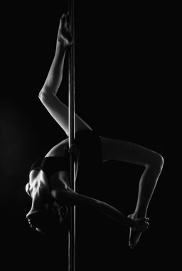 Direk dansı. Siyah iç çamaşırlı, siyah arka planda esneyen seksi balerin. Bale sanatı kavramı. Seksi direk dansçısı. Harika vücutlu güzel seksi fitness kızı mükemmel vücudunu esnetiyor.