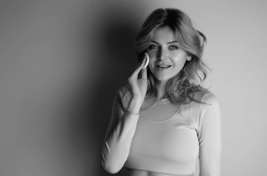 Woman removing makeup, holds cotton pads. Cleansing treatment care for skin with cotton pad. Young woman beauty model applying skin care product using a cotton pad