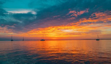 Denizde gün batımı güzel bulutlarla. Güneş doğarken okyanus manzarası
