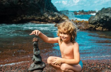 Çocuk öğrenme sıralaması ya da çakıl taşı kulesi ya da piramidi denge, eğitim ve doğa ile meditasyon için suya yığmak, çocuklar yaz tatilinde dinlenir