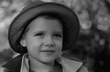 Çocuklar sonbahar parkında oynarlar. Sarı yapraklı çocuk portresi. Hayalci çocuk suratı. Hayalperest çocuk portresi yakın plan. Hayaller ve hayal gücü. Hayalci okul çocuğu suratı.