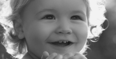 Çocuk portresi, sevimli çocuğun başını yakın çekim. Bebek gülüşü, güneşli bir günde tatlı bir gülümseme. Hayalci çocuk suratı. Hayalperest çocuk portresi yakın plan. Hayaller ve hayal gücü. Hayalci okul çocuğu suratı.