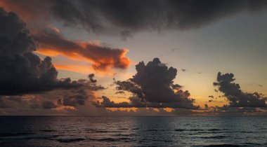 Tropikal deniz okyanusunda gün batımı ve gündoğumu bulutları. Seyahat tatili afişi. Manzara gökyüzü ve yansıma ışınları. Alacakaranlık, denizde alacakaranlık. Sakin, altın gökyüzü arka planı