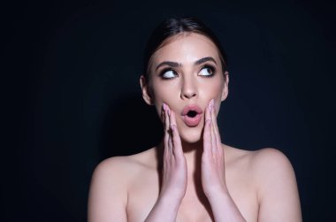 Girl raising eyebrows being surprised and shocked. Astonished reaction on unexpected news. Girl in t-shirt on isolated studio background with shocked, surprise and amazed expression on face