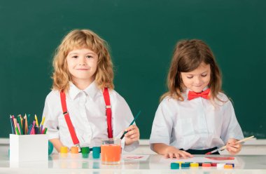 Resim okulu öğrencileri resim ödevi yapıyor. Çocuklar ilkokulda resim çiziyor. Çocukların yaratıcı eğitimi