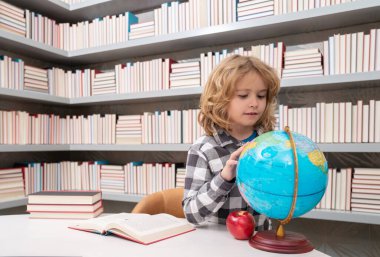 Back to school. School and students in classroom. Education kids. Studying and learning concept. School boy in the library near school supplies. Kid learn geography with globe