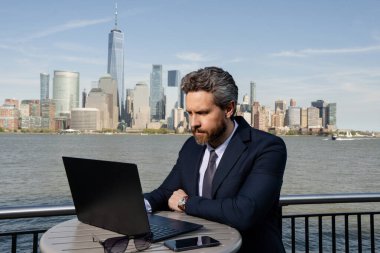 New York 'ta dışarıda dizüstü bilgisayar kullanan bir iş adamı. İş dünyası Amerikan başarısı. Amerikan iş rüyası. Manhattan yakınlarında takım elbiseli Amerikalı iş adamları. ABD 'de online iş