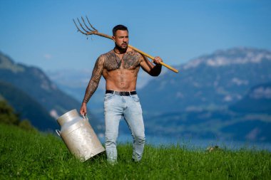 Çim çiftliğinde çalışan bir adam. Ekoloji konsepti. Çiftçi. Tarlada tarla işçisi. - Evet. Yaz tarlasında çiftçi. Kırsal tarım arazisindeki çiftçi. Çimenlikteki seksi çiftçinin portresi. Biyolojik ekoloji kavramı