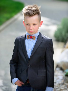 Takım elbiseli ve papyonlu çocuk. Komik çocuk duyguları. Açık havada, dışarıda oynayan sevimli küçük bir çocuğun portresi. Dışarıdaki güzel çocukların portresi.