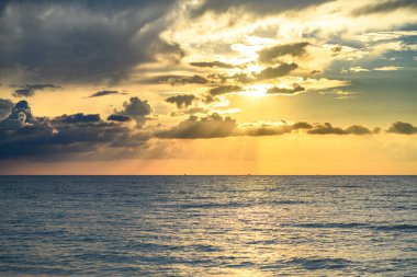 Gün batımlı ya da gün doğumlu deniz sahili. Gün batımı denizi üzerinde bulutlu bir manzara. Tropik plajda gün batımı. Doğanın günbatımı gökyüzü. Dramatik bulutlar