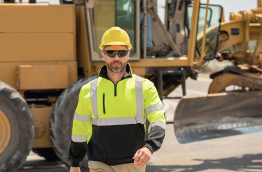 İnşaat işçisi inşaat halinde. Erkek inşaatçı inşaat alanında çalışıyor. Amerikan inşaat sahasında miğferli mühendis portresi.