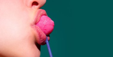Kadın ağzında lolipop, kırmızı ruj. Kırmızı, parlak bir lolipopu yalayan bir kadın. Kapatın. Seksi ağzında lolipopla seksi bir kadın.