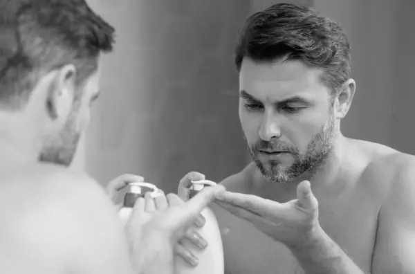 stock image Beauty portrait of hispanic man applying face cream. Skincare cream, skin anti-aging wrinkle effect. Man applying moisturizer cream on skin. Skin care, cosmetic cream treatment for male face