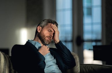 Baş ağrısı, yorgunluk ve stres. Takım elbiseli adamın yakın plan portresi baş ağrısı yapıyor. Baş ağrısı konsepti. Ofiste acılı adamlar streslidir. Stresli ve baş ağrısı