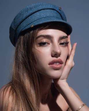 Seductive sexy lovely attractive young sensual woman with beauty face posing on studio background. Beautiful elegant sexy model with cap, studio portrait. Sensual beautiful woman face