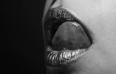 Altın dudaklı kadın yüzünü kapat. Ağzında altın boya var. Altın dudaklar. Lüks altın dudaklar makyaj. Yaratıcı metalik rujlu altın dudaklar. Seksi dil.