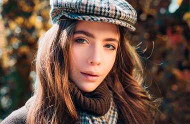 Güneşli gün ışığı açık portre güzel esmer modeli kız. Doğa arka plan üzerine düşen yaprakları ile sonbahar kırmızı elbiseli güzel moda kadın. Romantik kız sanat çalışmaları