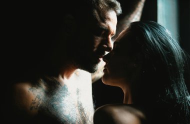 Romantik genç çiftin yakın çekimi birbirlerini öpüyor. Hassas tutkuları olan seksi, zarif çift aşıkları. Birbirine aşık güzel seksi bir çiftin portresi. Erkek, şehvetli kadını öper. Romantik çiftler kucaklaşır