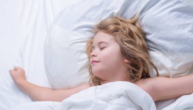 Sabah uykusu. Çocuk yatakta uyuyor. Çocuk battaniyenin altında uyuyor. Çocuk yastığa uzanır, çocuk uyur, sağlıklı bir uyku çeker ya da kestirir.