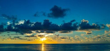 Dramatik gün batımı ve bulutlu gökyüzü. Deniz. Bulutların arasından bulutlu bulutlu bir deniz. Günbatımı okyanusu ve bulutlu gökyüzü arkaplanı. Huzurlu deniz manzarası. Günbatımı deniz suyunun üzerinde bir ufuk. Sakin bulutlu gökyüzü