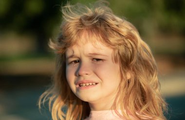 Dışarıda ağlayan çocuğun yakından çekilmiş yüzü. Çocuklar ağlar. Oğlan dargınlık ve keder içinde ağlıyor.