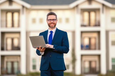 Dışarıda dizüstü bilgisayarda çalışan bir adam. Adam dizüstü bilgisayardaki e-postaları kontrol ediyor, sosyal ağda mesaj yazıyor, interneti kullanıyor, dışarıdaki bilgisayarlarda bilgi arıyor. Ev yakınlarında dizüstü bilgisayar kullanan bir adam.