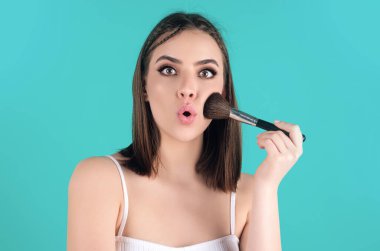 Woman applying foundation powder or blush with makeup brush. Facial treatment, perfect skin, natural make up, facial beauty. Isolated on studio background. Applying makeup