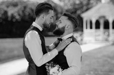 Düğünde eşcinsel damat. Eşcinsel evlilik ve aşk kavramı. Düğünde mutlu eşcinsel çift. Romantik ve şehvetli eşcinsel çift. Eşcinsel damatlar düğün gününde birlikte