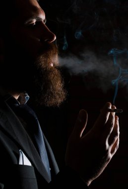 Man smoking cigarette isolated on black studio