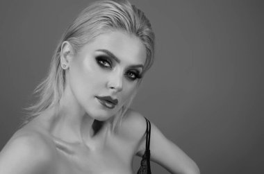 Güzel yüzlü, pürüzsüz ciltli, çıplak omuzlu, şehvetli bir kadın. İzole edilmiş stüdyo arka planında doğal makyajlı ve güzel gözlü seksi bir model. Çıplak omuzlu güzel seksi manken kız.