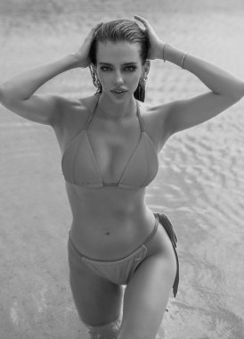 Yüzme havuzunda bikinili, havuz başında seksi poz veren güzel bir kadın. Yaz tatili. Oteldeki havuz başında bikini mayo giymiş seksi, bronzlaşmış bir kadının fotoğrafı. Yaz turizmi