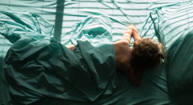 Çocuklar uzanır ve yastığın üzerinde uyur. Sabahları yatak odasında rahat bir şekilde uyuyan çocuk manzarası.