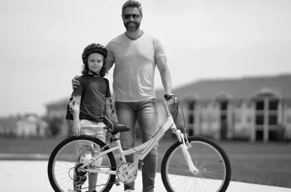 stock image Kids insurance. Father and son are riding bike together on summer weekend. Happy playful dad with excited kid son riding a bicycle on weekend. Sporty family. Fathers day