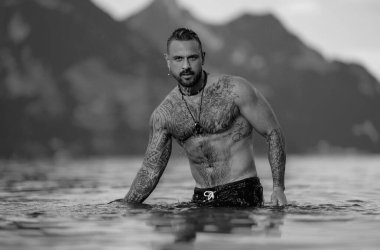 Sudaki seksi adam. Üstsüz erkek cesedi. Seksi manken. Doğada baştan çıkarıcı bir adam. Yakışıklı, üstsüz bir adam. Kaslı erkek vücudu fit. Kas modeli, sporcu genç adam. Kaslı erkek gövdesi