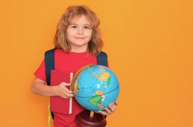 Bilgi toplama günü. Dünya küresi ve kitabı olan okul çocuğu. İlkokuldan bir çocuk. Küçük öğrenci, zeki inek öğrenci çalışmaya hazır. Bilgi, eğitim ve öğrenim kavramı.