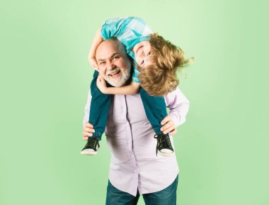 Yaşlı büyükbaba ve küçük çocuk, komik yüzlü, yalıtılmış bir şekilde sırtında taşıyorlar. Yaşlı bir akraba ve çocuk.