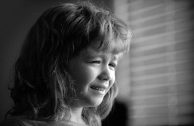 Ağlayan çocuk. Evde gözyaşı döken üzgün çocuk.