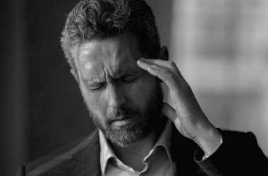 Sinüs ağrısı, gerilim ya da küme baş ağrısı olan bir adam, portreyi kapat. Baş ağrısı konsepti. Cephalalji ve migren. Migren belirtileri. Kronik baş ağrıları. Baş ağrısı tetikleyiciler