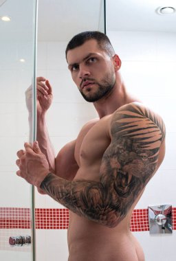 Seksi kaslı adam banyoda duş alıyor. Çıplak vücudu yıkayan adam. Erkek vücut bakımı, güzellik rutini ve günlük temizlik. Banyoda çıplak gövdeli bir adam var. Sabah rutini. Sabah taze.