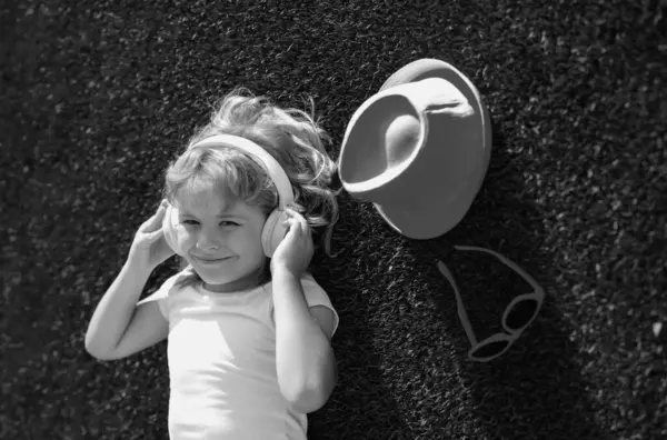 stock image Portrait of happy smiling child in headphones listening to music. Young child boy with headphones listening to music outdoor