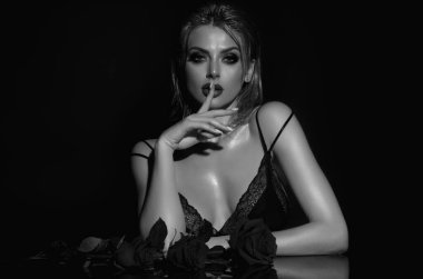 Kırmızı güllü seksi kadın. Stüdyo güzelliği portresi. Kırmızı gül çiçekli güzel bir kadın.