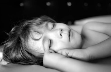 Pijamalı çocuklar beyaz arka planda yatıyorlar. Yatma zamanı.