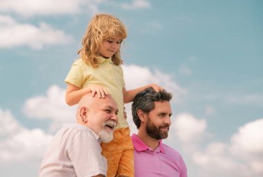 Genç baba, tatlı çocuk ve yaşlı büyükbaba. Büyükbaba ve oğul çocuk portresi. Babalar Günü. Farklı yaşlardaki erkekler.